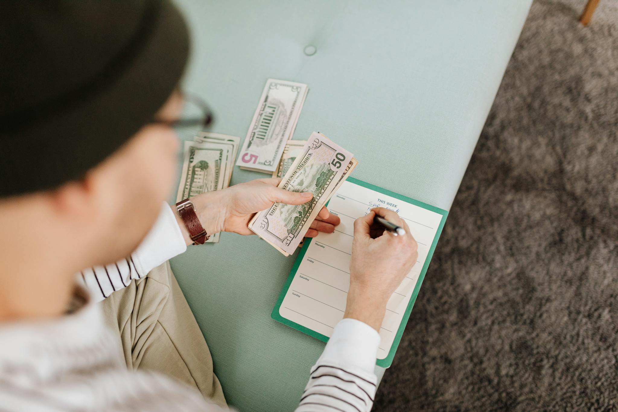 Individual budgeting with US dollars and a planner, focusing on financial planning.
